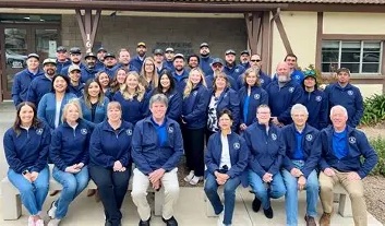 Elizabeth Orona with a large community group in matching jackets.